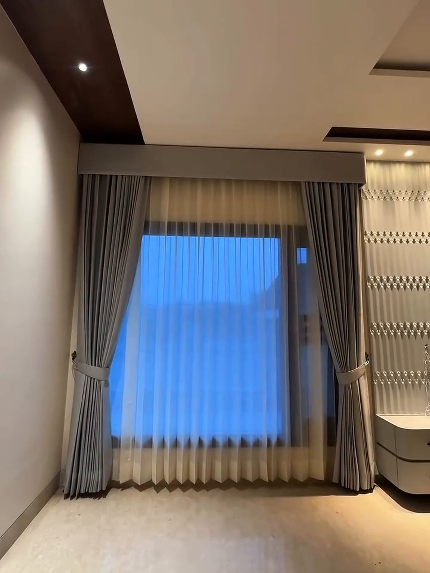 Sheer and drape curtains installed over a bedroom window